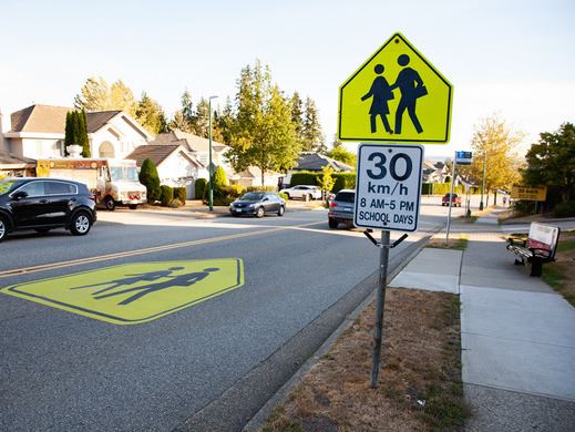 https://www.tricitylocalnews.com/wp-content/uploads/2025/08/A-school-zone-sign-in-Coquitlam-shows-a-30-kmh-speed-limit-from-8-a.m.-to-5-p.m.-on-school-days-with-cars-driving-past-houses-on-a-residential-street.jpg
